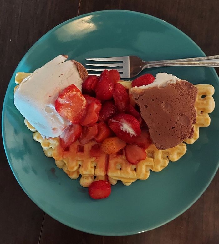 Waffles and ice cream with strawberries.