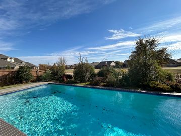 Clear blue swimming pool under a sunny sky.