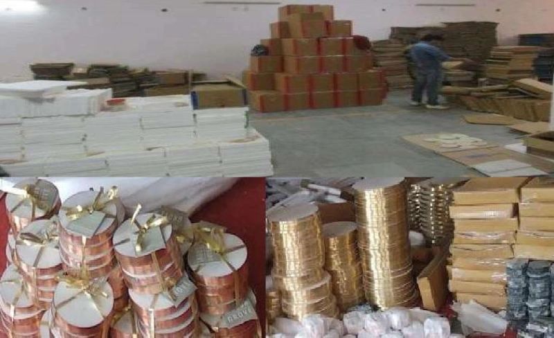 Stacks of cardboard boxes and rolls of ribbons in a warehouse.