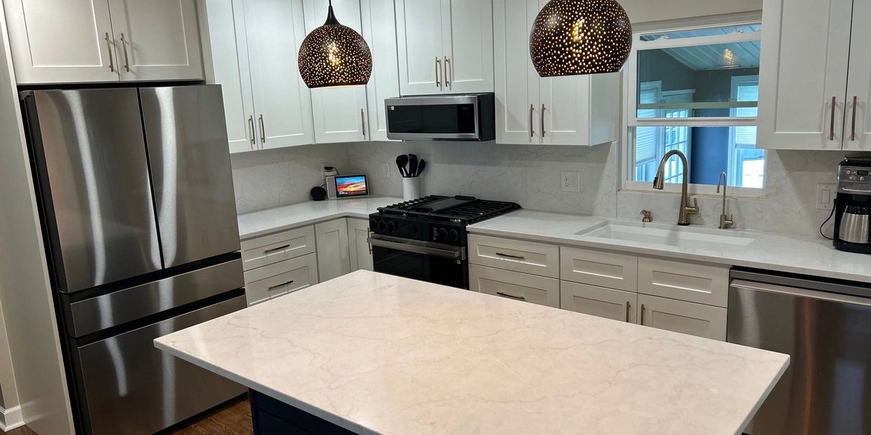 Modern kitchen with white cabinets and stainless steel appliances.