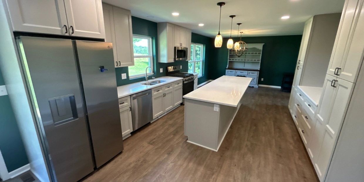 Modern kitchen with white cabinetry and stainless steel appliances.