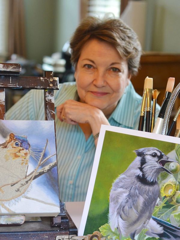 Artist with art and paint brushes displayed.