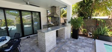 L shape outdoor kitchen that has a floating bar