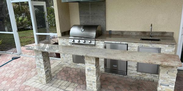 Custom built outdoor kitchen with a floating bar. Allows guests to sit on either side