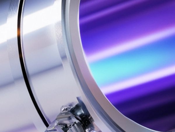 Close-up of a shiny metallic cylindrical object with a purple reflective surface.