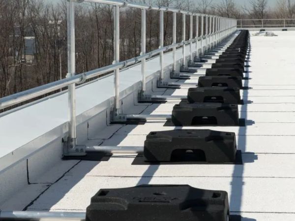 A rooftop safety railing system with weighted bases.