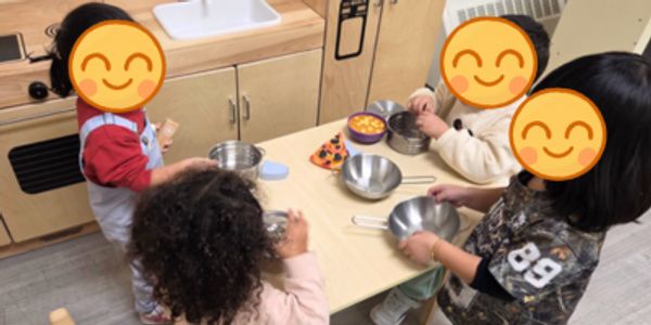 Children engaging in a cooking activity around a small table.