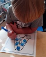 Carter is using his fine motor skills to color in the apples in the letter A. 