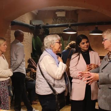 Three women engaged in a lively conversation indoors.