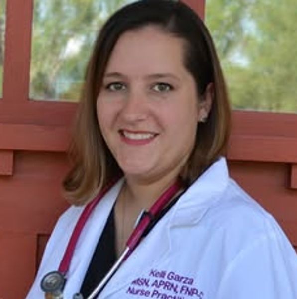 Smiling nurse practitioner in white coat with stethoscope.