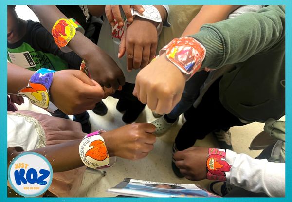 Children showing colorful handmade wristbands in a group.