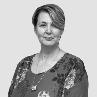 Black and white portrait of a woman in a floral blouse.