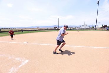 People playing baseball on a sunny day.