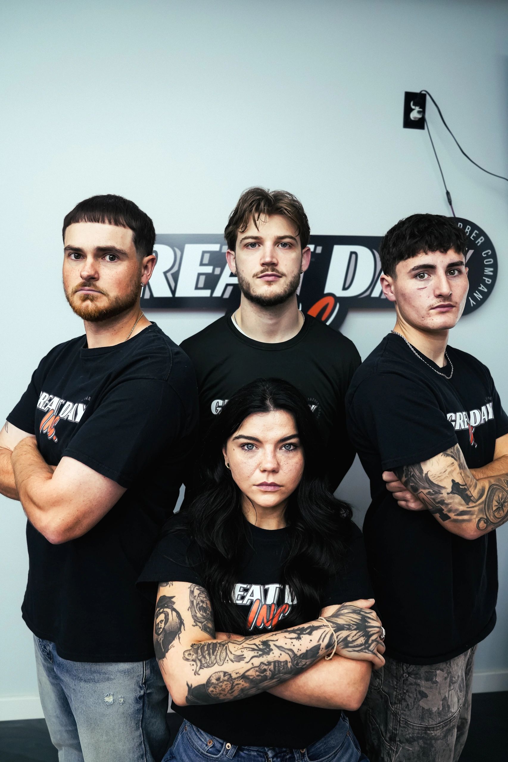 Group of serious young people with tattoos posing indoors.