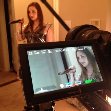 Photo of the screen of a camera in the middle of filming. An actress is holding a bloody knife. 