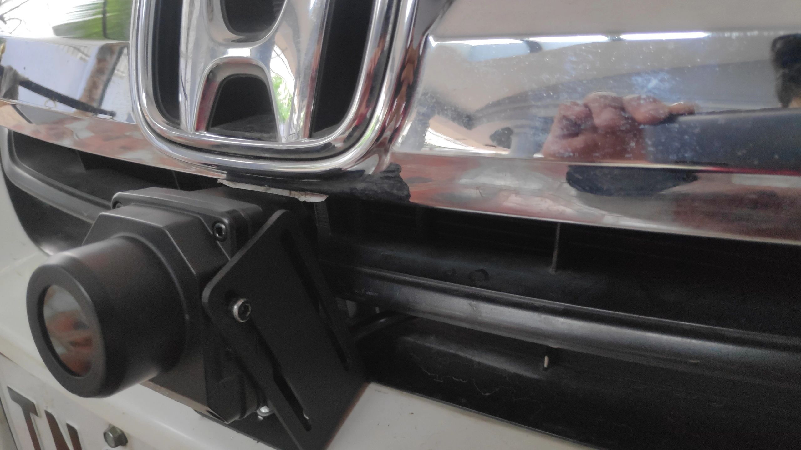 Close-up of Honda car front grille with mounted accessory.