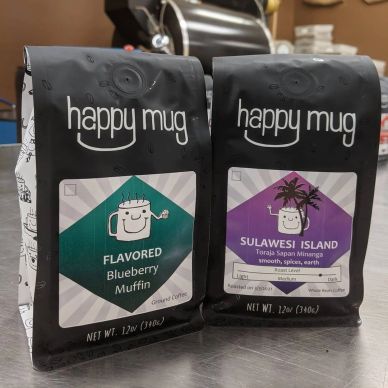 Two bags of Happy Mug coffee on a counter.