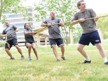 Group playing tug of war outdoors.