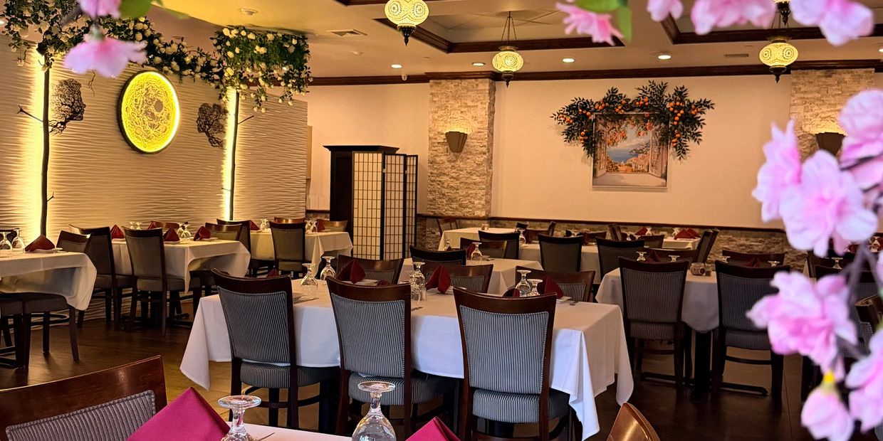 Elegant restaurant interior with white tablecloths and floral decorations.