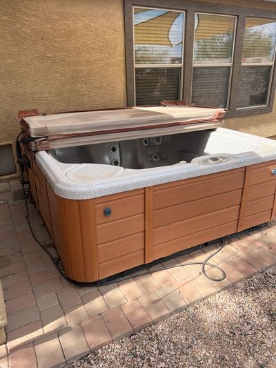 Empty hot tub in Maricopa, Az with the cover half removed.