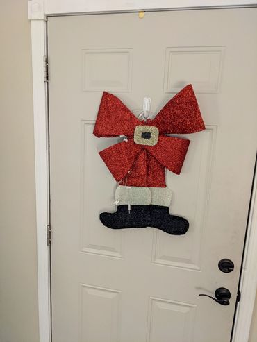 A white for with a holiday decoration of a red bow and black boots