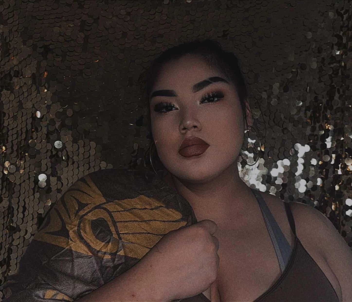 Confident native woman with bold makeup and a large tattoo on her arm.