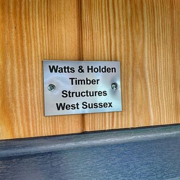 Metal sign of "Watts & Holden Timber Structures West Sussex"