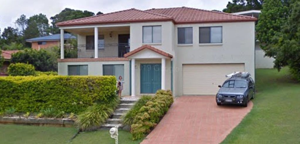 A modern two-story house with a driveway and parked car.