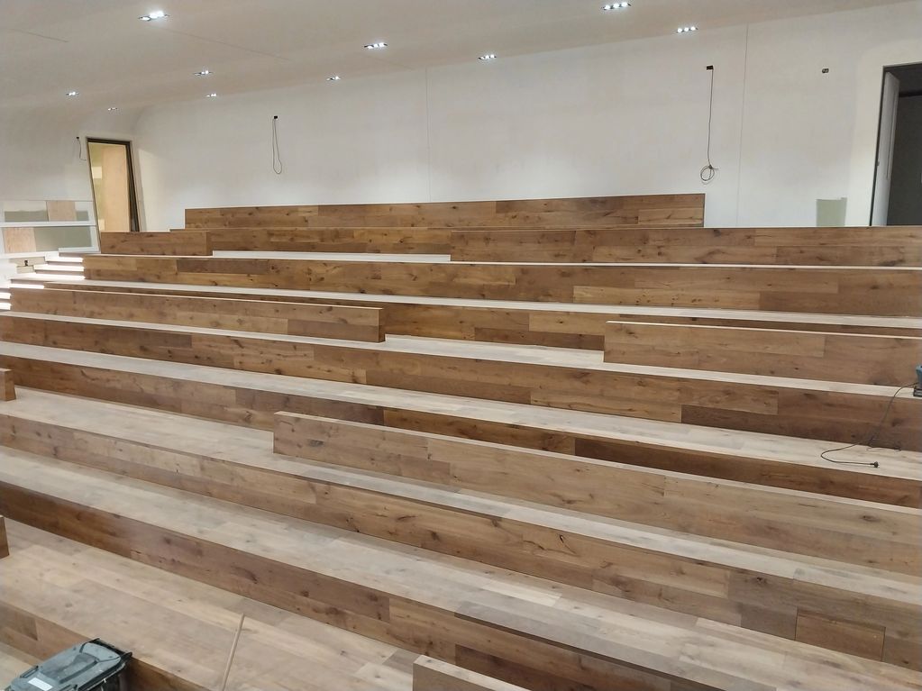 Modern indoor tiered wooden seating in a minimalist room.