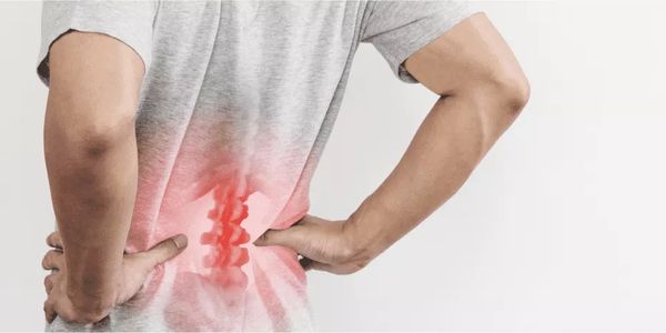 Person holding lower back, highlighting pain area with red glow.