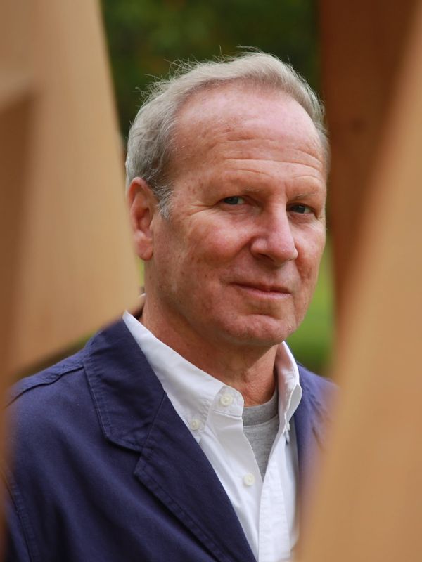 Middle-aged man wearing a navy jacket and white shirt.