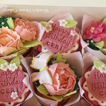 Beautifully decorated birthday cupcakes with floral and butterfly designs.