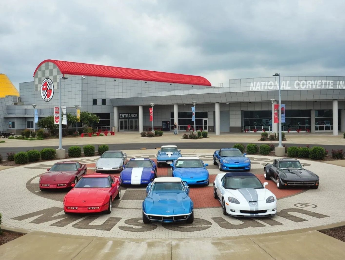 A lineup of Corvette cars displayed in front of the National Corvette Museum.