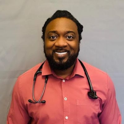 Smiling doctor with stethoscope wearing a red shirt.