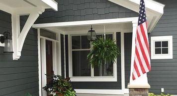 A house exterior with gray paint and an American flag 