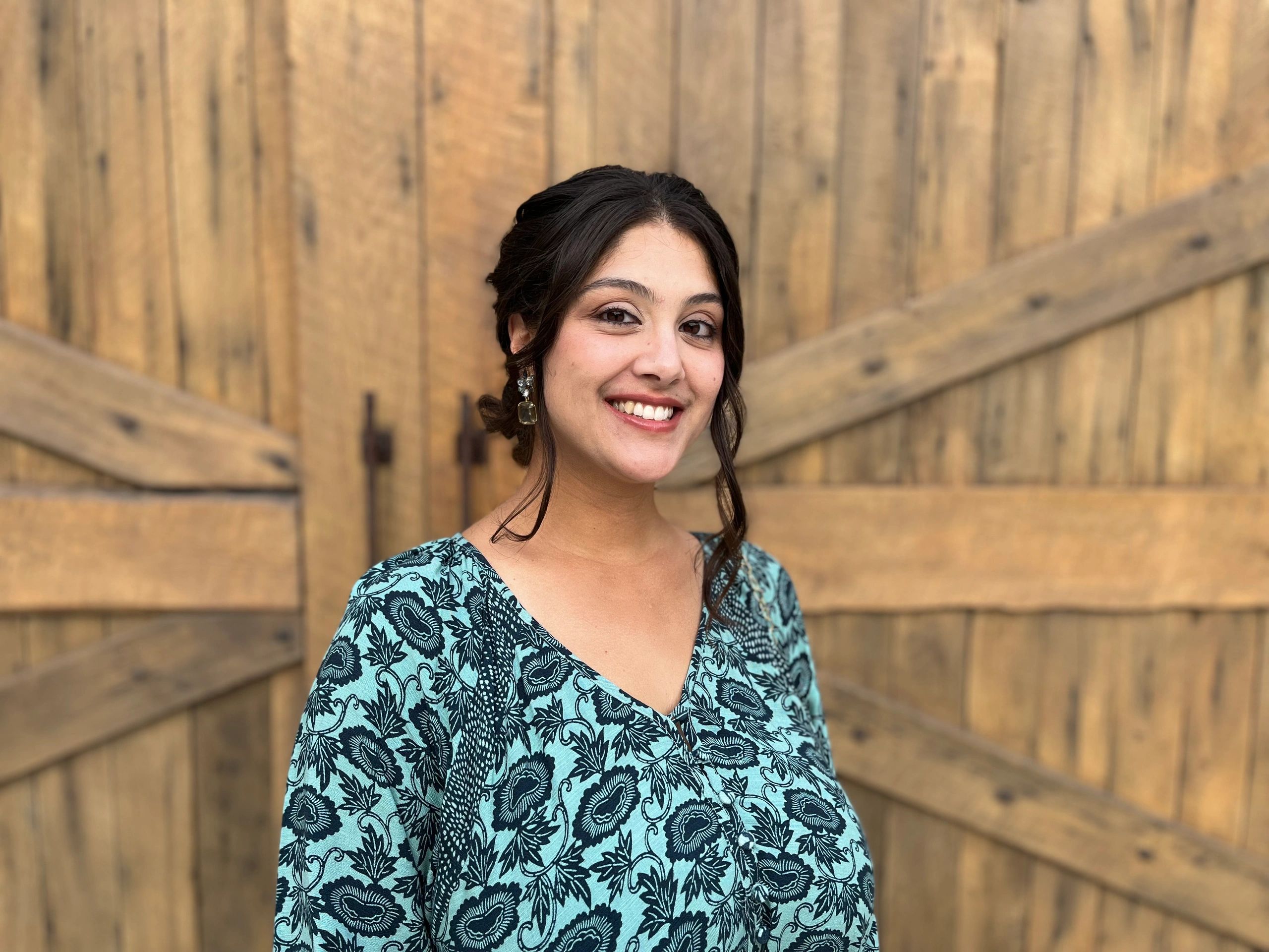 Smiling woman in blue patterned dress.