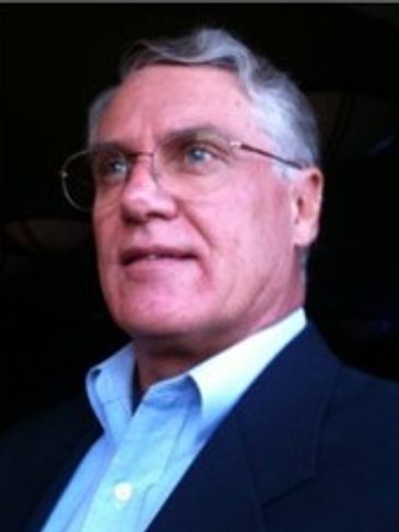 Portrait of an older man with glasses and gray hair.