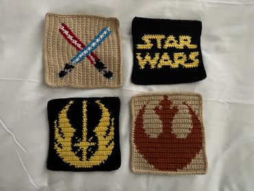 Crocheted Star Wars-themed squares with symbols and lightsabers.