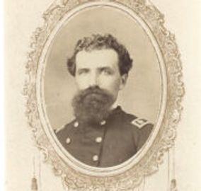 Portrait of a bearded man in a military uniform framed ornately.