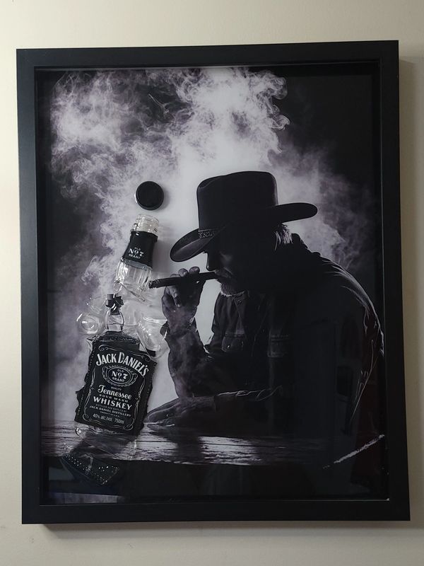 Man with a cigar and Jack Daniel's whiskey in a smoky atmosphere.