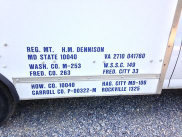 White vehicle side with blue registration text and county codes.