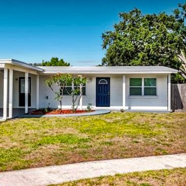 Single-story house with a blue door and a front yard.