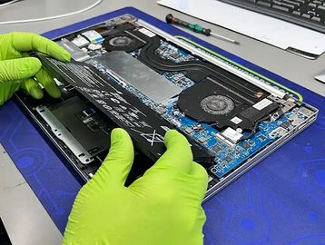 a person replacing a laptop batery