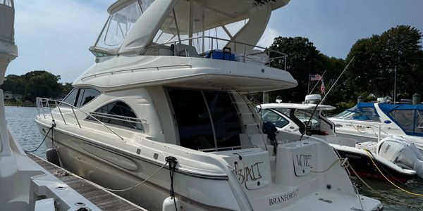 White luxury yacht docked at a marina on a sunny day.
