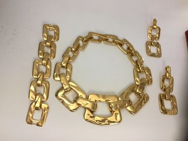 Gold chunky chain jewelry set with necklace, bracelet, and earrings.