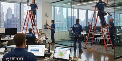 Technicians from Liftoff Solutions working on wiring and monitoring in a modern office.