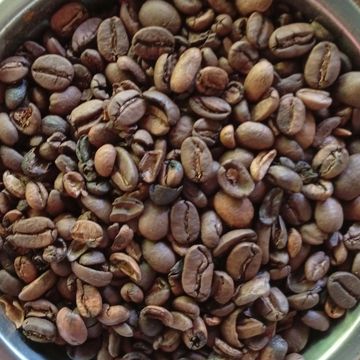 Granos de café tostado en un recipiente.