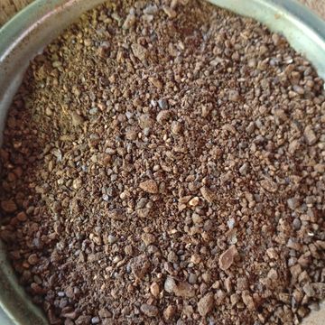 Café molido grueso en un recipiente.