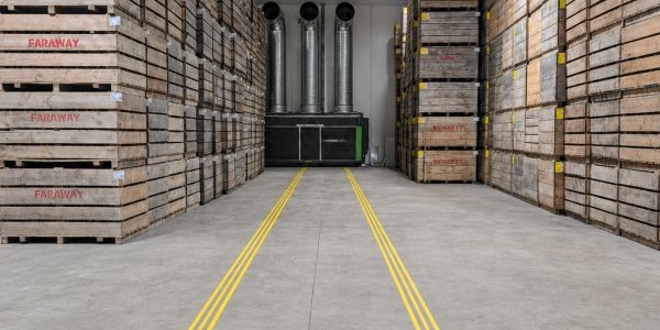 Warehouse aisle with wooden crates stacked on either side.