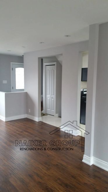 Newly renovated room with wooden flooring and gray walls.
